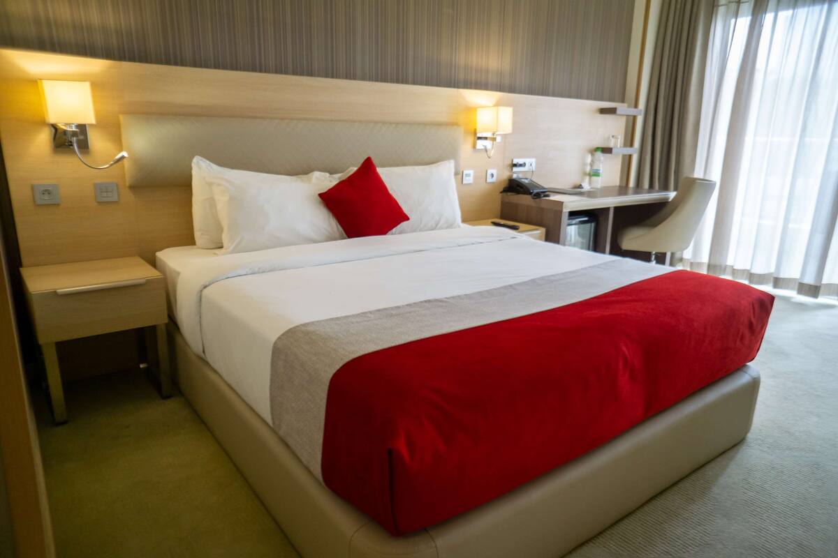 Una habitación de hotel con una cama grande, un escritorio y una silla.