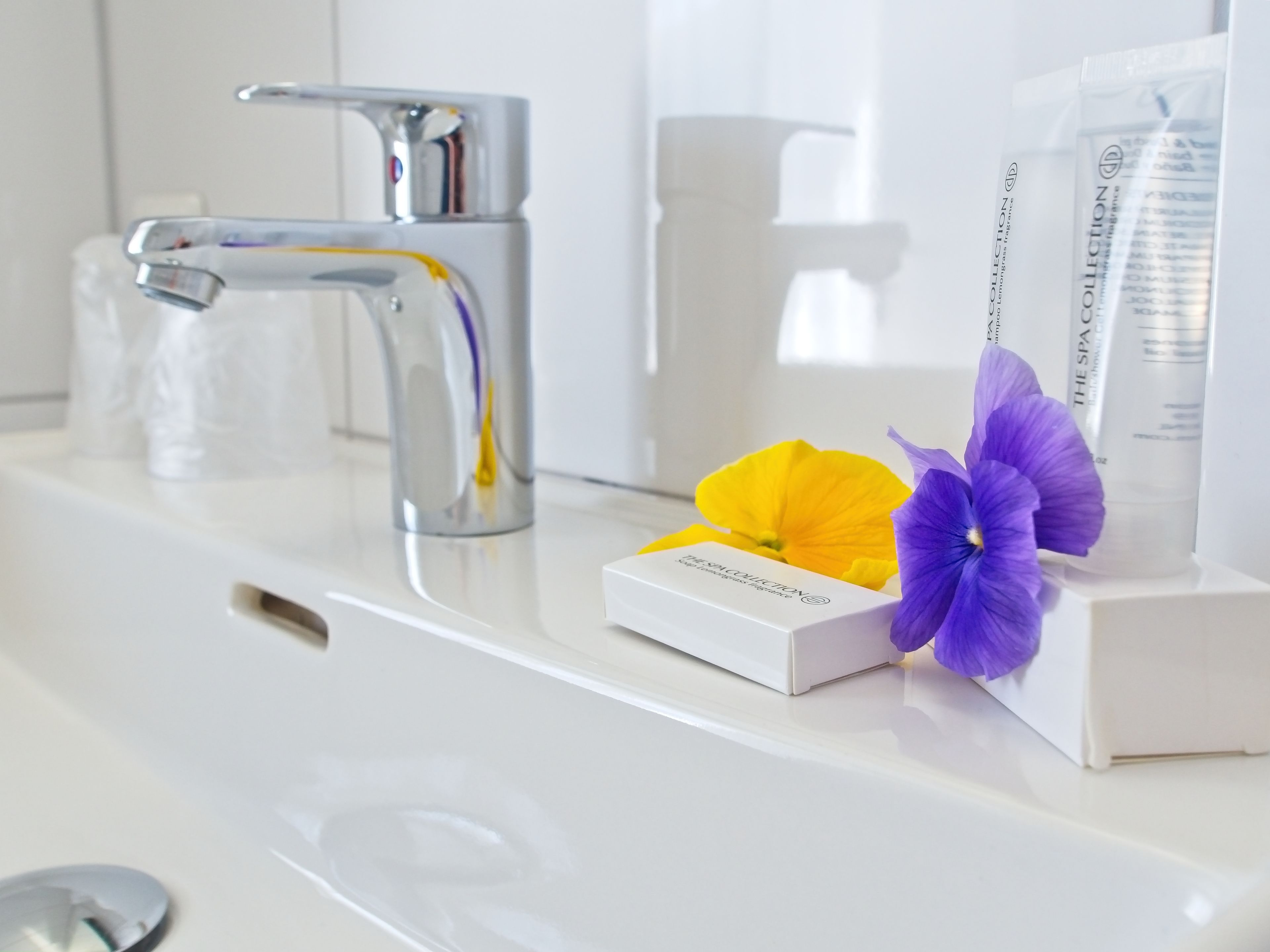 A bathroom with a white sink, a chrome faucet, and a box labeled "Spa Collection."