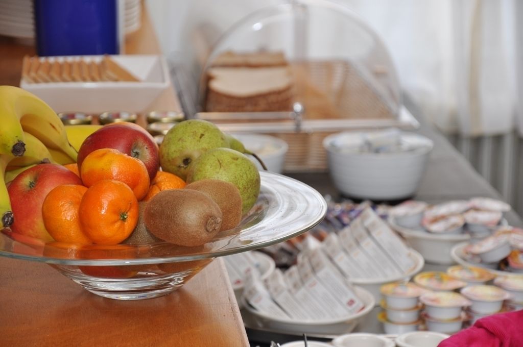 A buffet table with a variety of fruits and pastries.