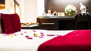A hotel room with a bed, a desk, a chair, and a vase of flowers. - Hotel San Jose Plaza (Bucaramanga)