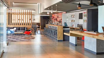 A modern interior with a bar area, seating, and a TV screen.