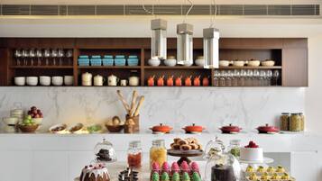 A kitchen with a marble countertop, various food items, and kitchenware.