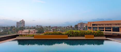 A rooftop swimming pool with a cityscape view.