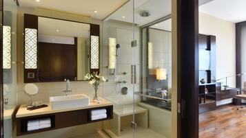 A modern bathroom with a glass-enclosed shower, a large mirror, and a white sink.