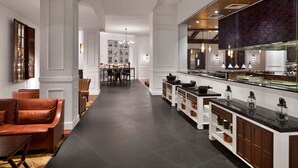Una cocina moderna con una encimera larga, armarios empotrados y una zona de comedor con mesa y sillas.