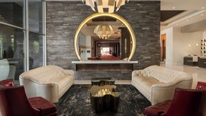 A modern lobby with leather sofas, a central fireplace, and a large mirror above it. - The Davenport Grand, Autograph Collection (Spokane)