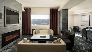 A modern living room with a fireplace, a large TV, and a view of a cityscape.