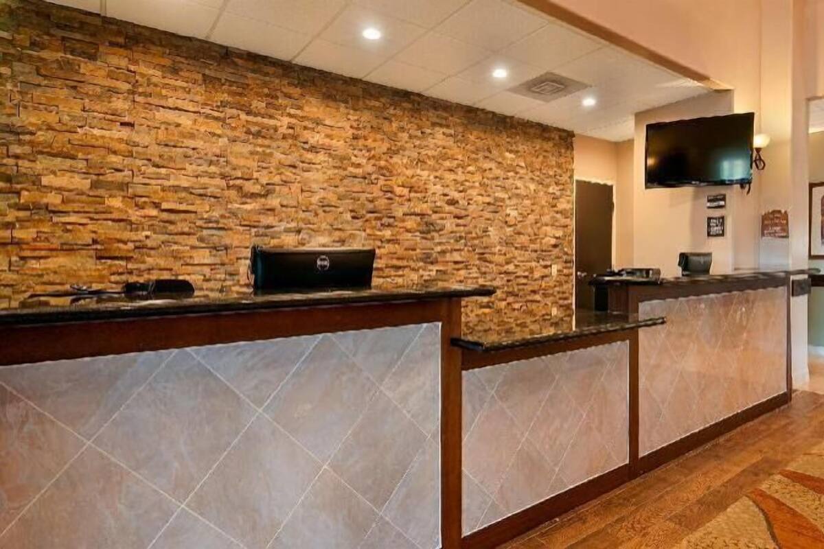 A reception area with a stone wall, a flat-screen TV, and a framed picture on the wall.