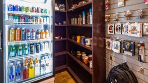 Máquina expendedora con diversas bebidas y una exhibición de llaveros y tazas.