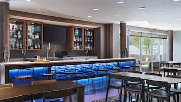 A bar area with a counter, seating, and a view of the outdoors.