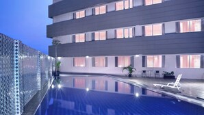 A modern hotel with a rooftop infinity pool, a glass fence, and a terrace with seating. - favehotel Jababeka Cikarang (Cikarang)