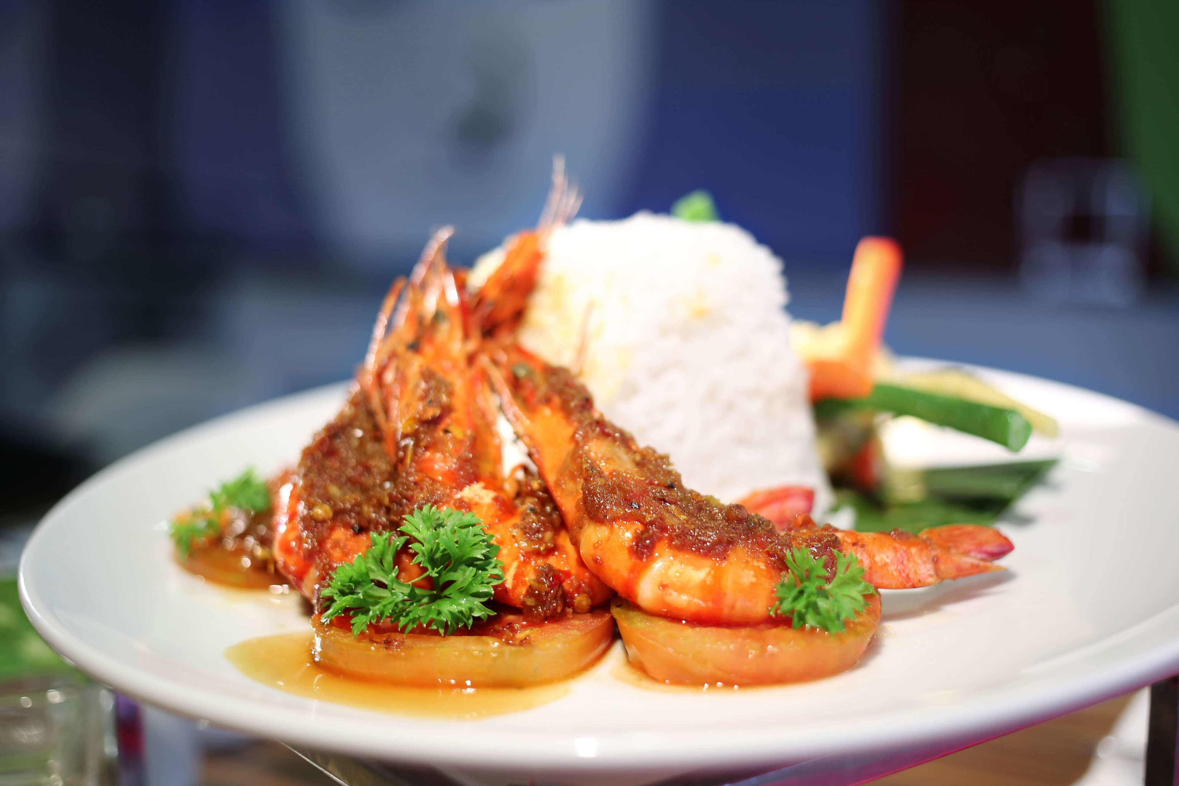 A plate of food with shrimp, rice, and vegetables.