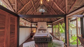 Una habitación con cama, zona de estar y ventana grande.