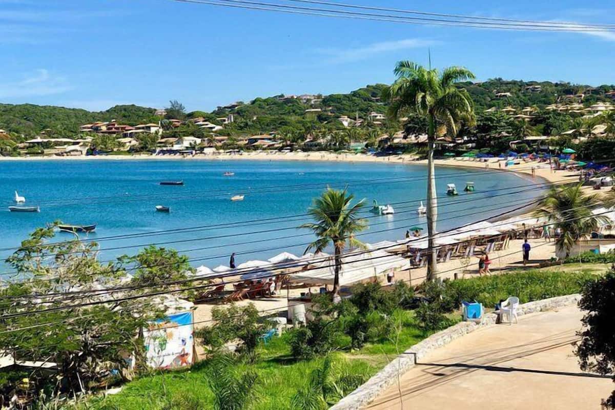 A coastal area with a beach, boats, and a clear sky.