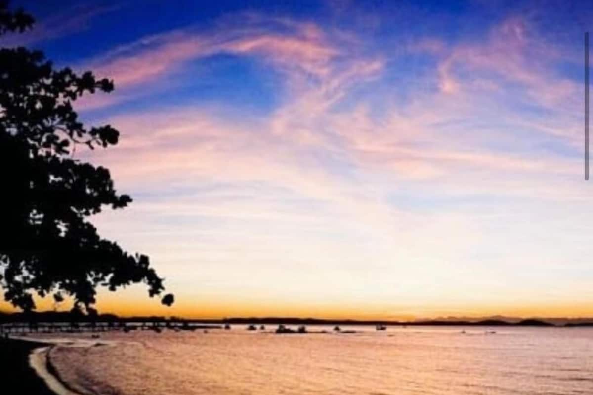 A beach scene with a clear sky and calm water.