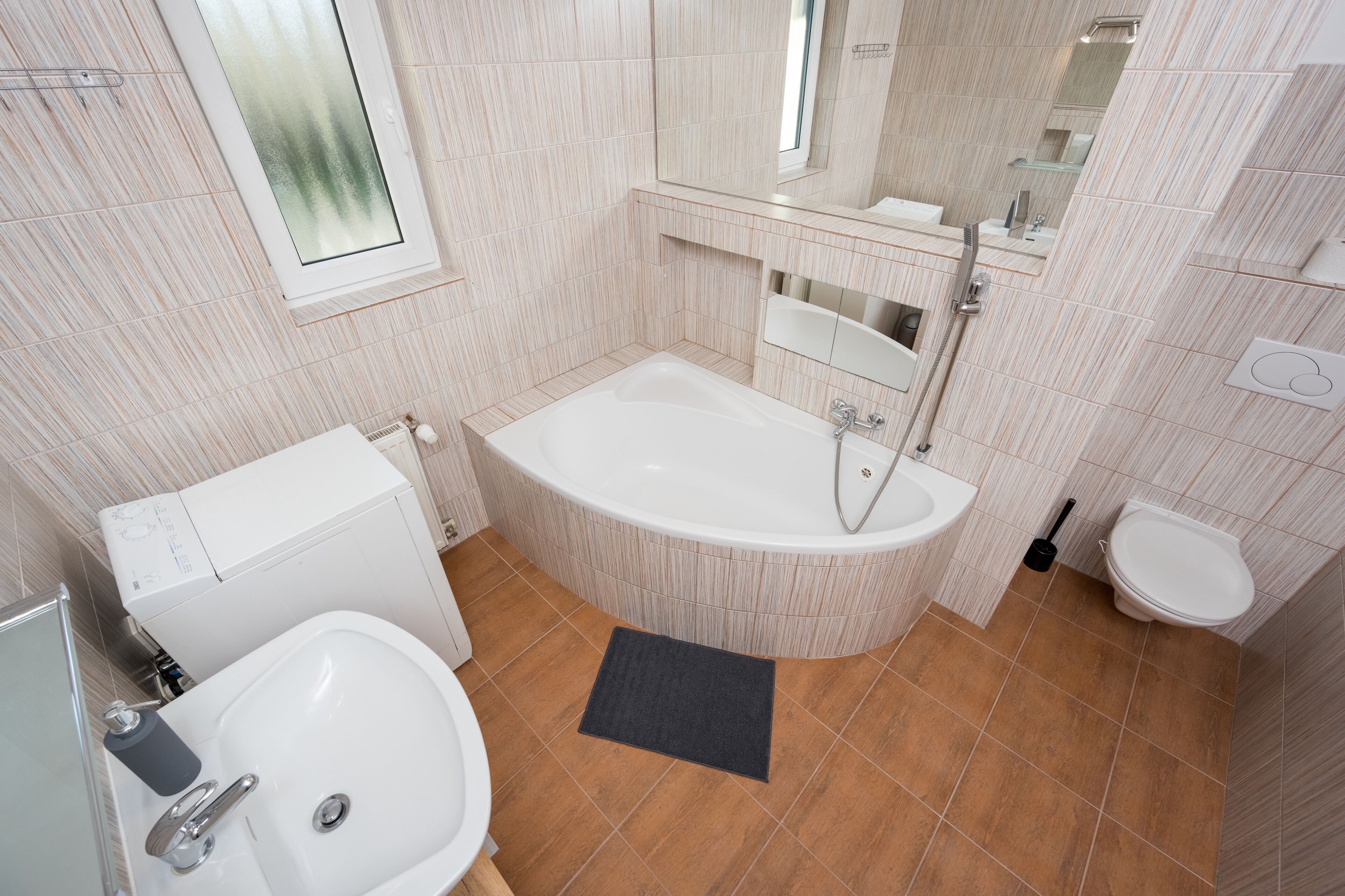 A modern bathroom with a bathtub, a sink, and a toilet.