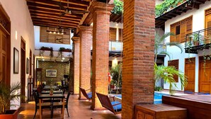 Un espacio interior amplio con piso a cuadros, mobiliario de madera y una zona de piscina.