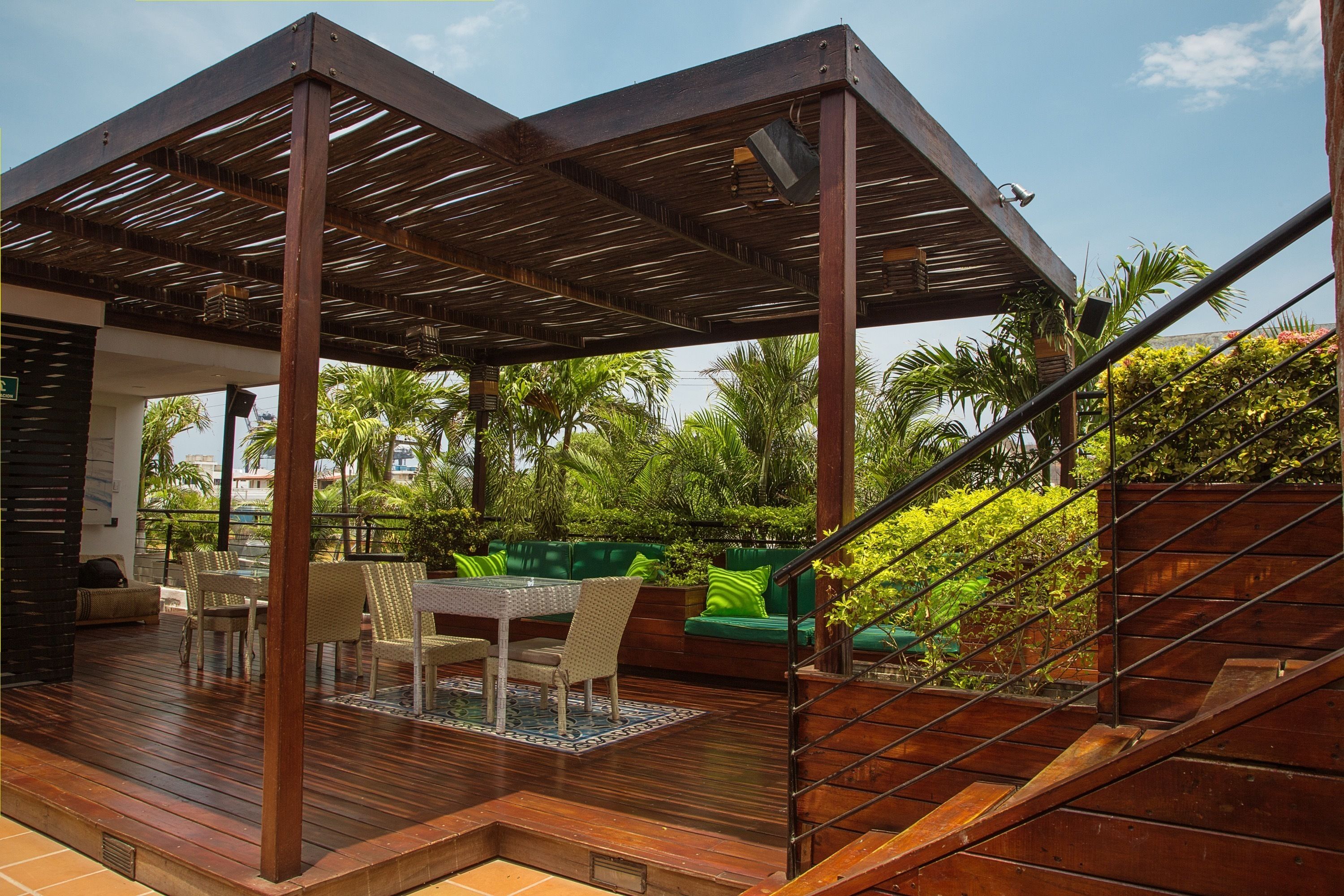 A covered outdoor area with a wooden deck, seating, and a staircase.