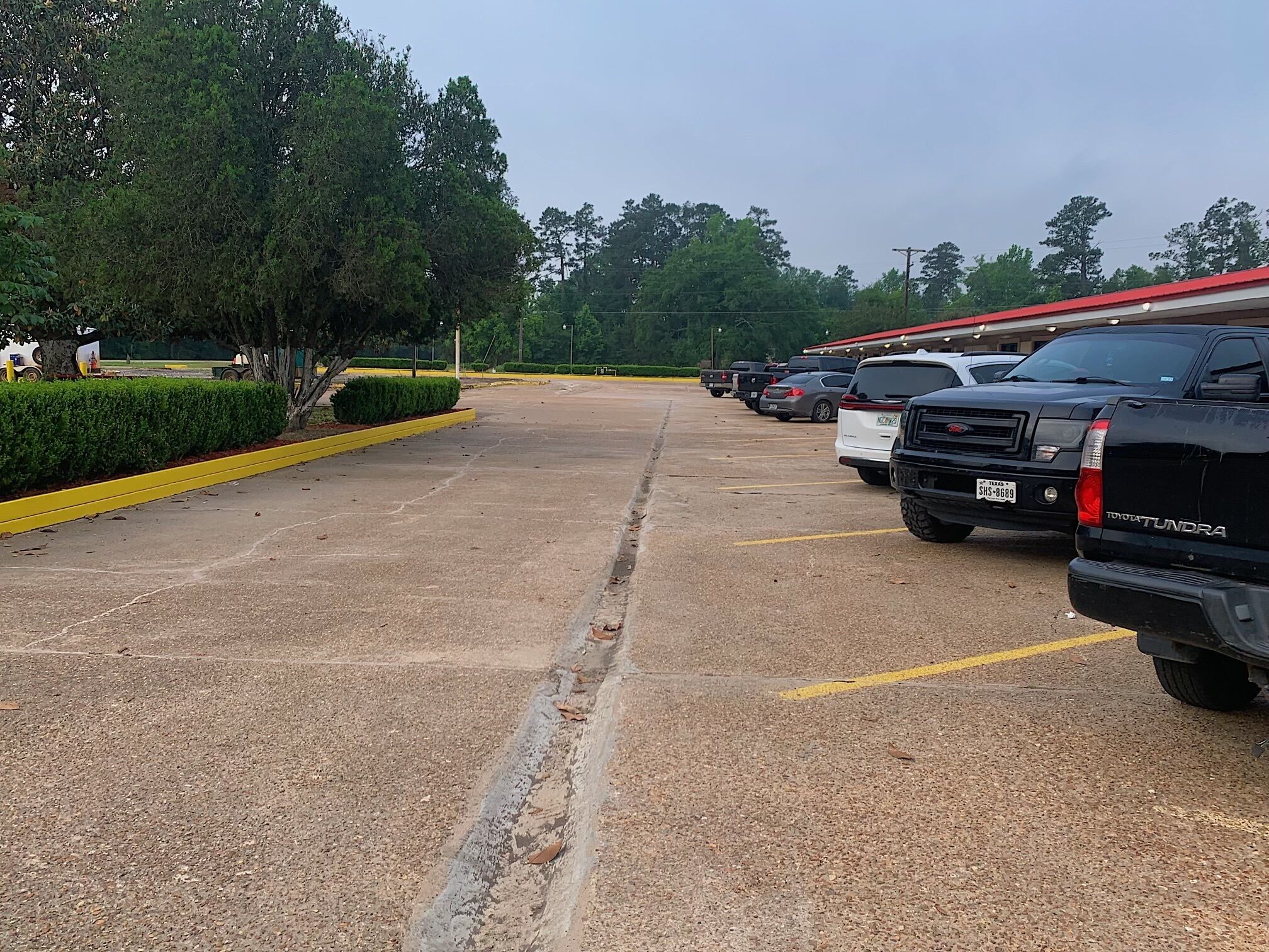 A parking lot with several SUVs and trucks parked.
