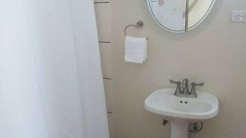 Ein Badezimmer mit Waschbecken, Spiegel und Duschvorhang.