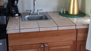 A kitchen with a sink, a coffee maker, and a large plant. - Casa de Tortuga (Vieques)