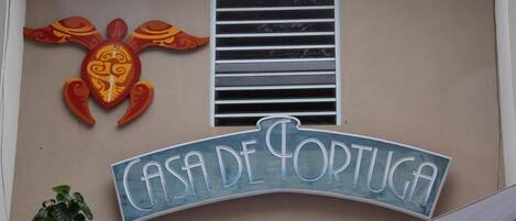 Une enseigne pour le « Casa de Portugal », ornée d’une tortue décorative et comportant une fenêtre avec des stores horizontaux.
