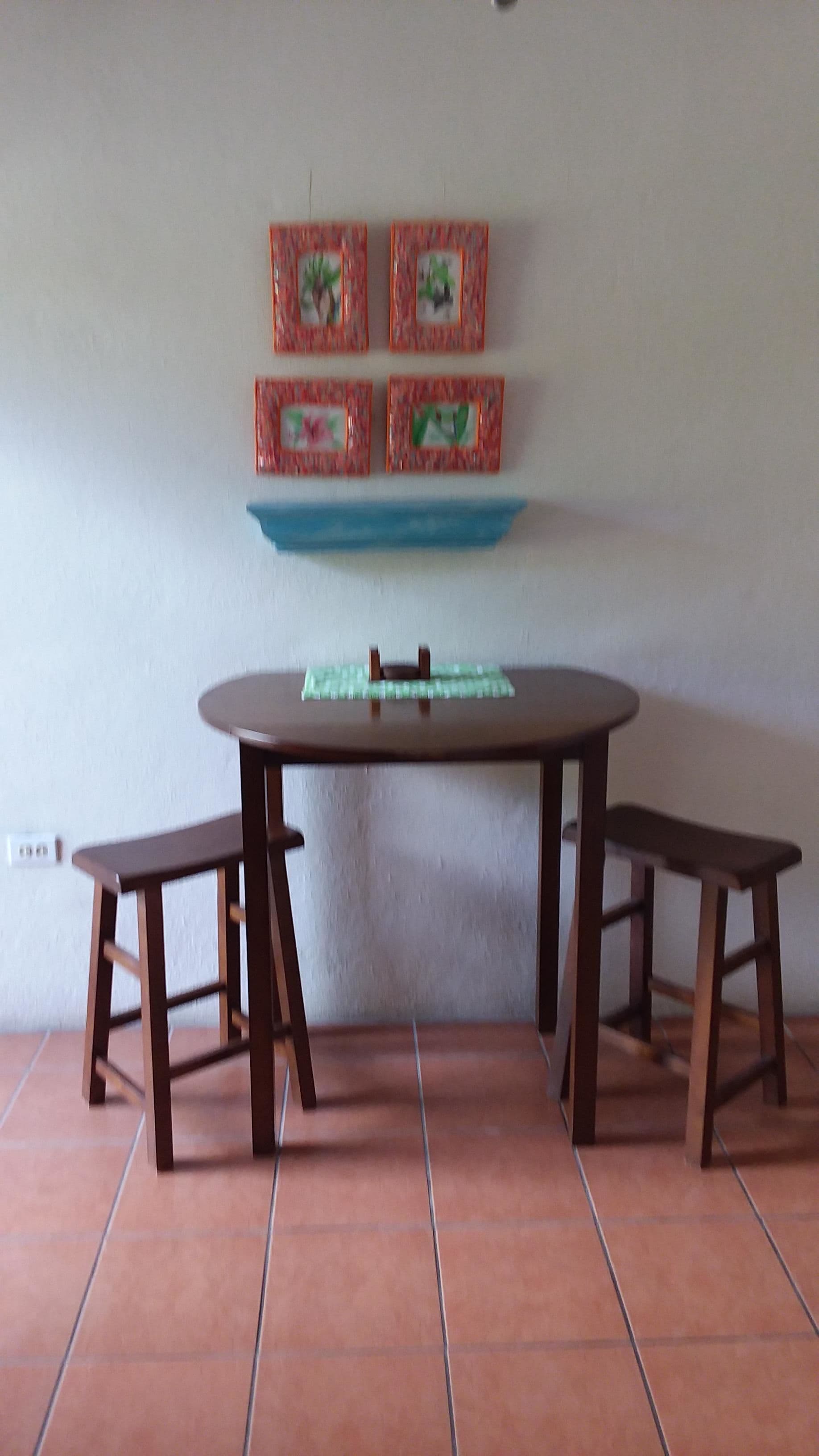 Un comedor con una mesa redonda y dos bancos.