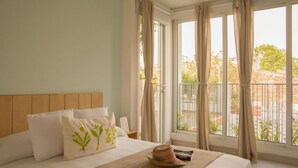 A hotel room with a bed, pillows, a hat, and a book on a wooden table. - La Casa del Patio Hotel Boutique by Xarm Hotels (Santa Marta)