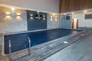 Una piscina al aire libre, sillones reclinables de piscina