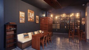 A cozy interior with a wooden dining table, cushioned seating, and a bookshelf. - Galapagos Native (Puerto Ayora)