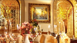 An elegantly set dining table with glassware, floral centerpieces, and a framed painting on the wall. - Gran Casa Sayula Hotel & Spa (Sayula)