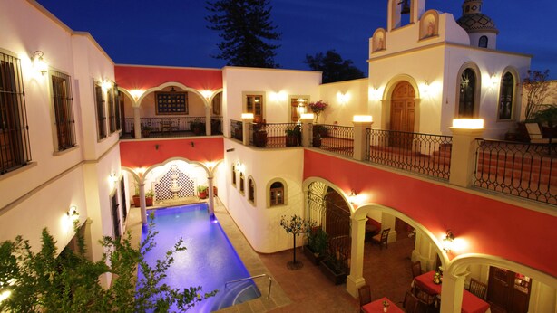 A courtyard with a swimming pool, multiple balconies, and a dining area with tables and chairs. - Gran Casa Sayula Hotel & Spa (Sayula)