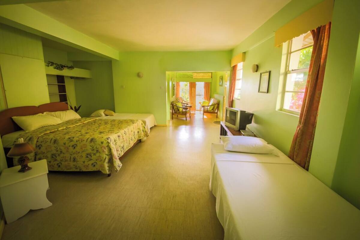 A room with two beds, a television, and a small table.