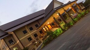Een hotel met meerdere verdiepingen, een plat dak en een overdekt buitengebied.