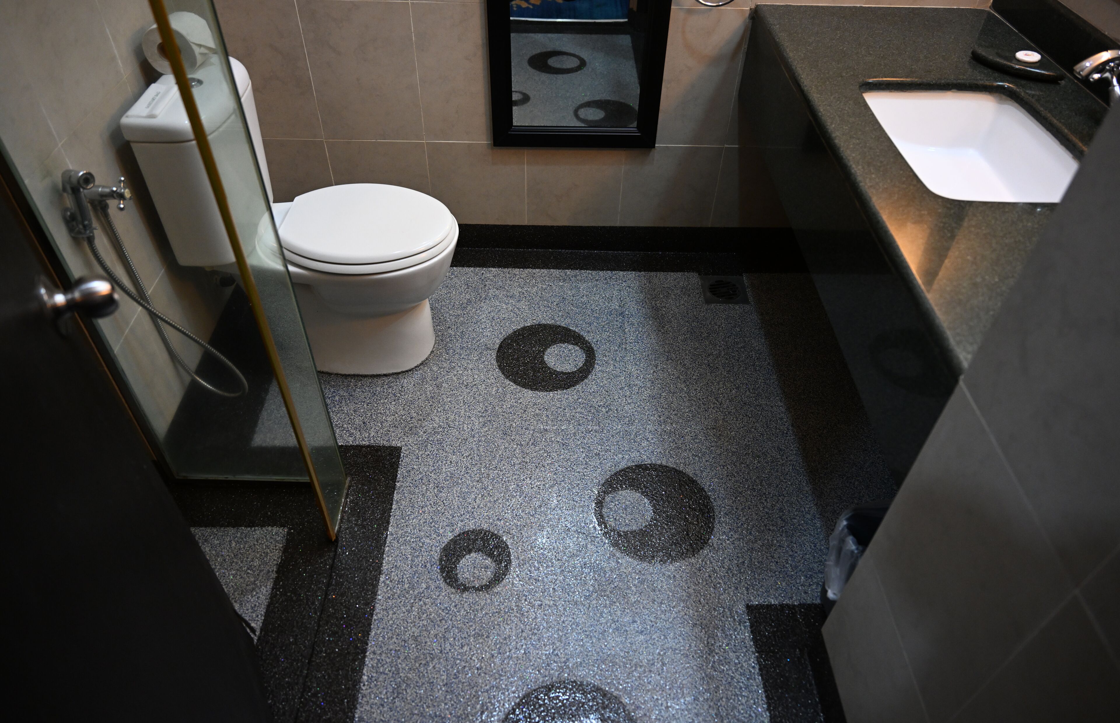 A bathroom with a toilet, a sink, and a shower area.