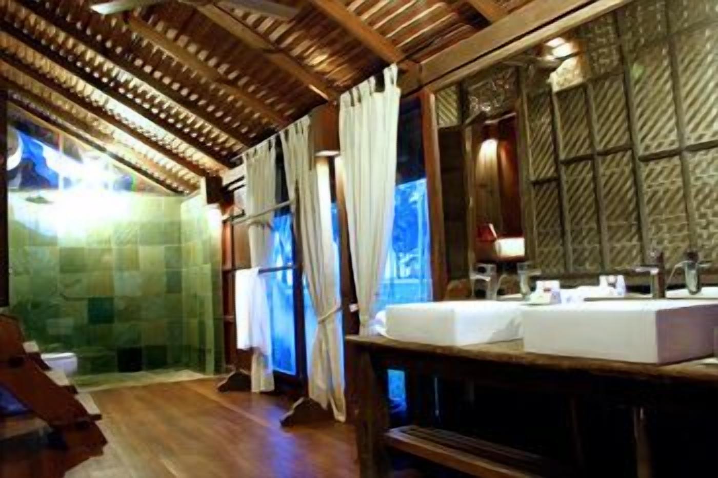 A bathroom with a wooden ceiling, a large mirror, and a sink.