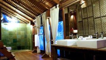 A bathroom with a wooden ceiling, a large mirror, and a sink.