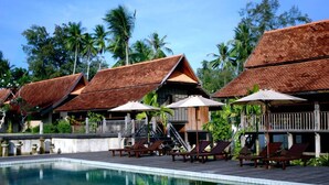 A pool area with overwater bungalows, each with a thatched roof and a small balcony. - Terrapuri Heritage Village (Setiu)