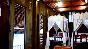 A traditional wooden room with two beds, each with a canopy.