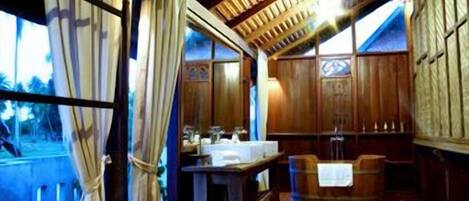 Un interior rústico de madera con un amplio ventanal, una mesa de madera y un banco.