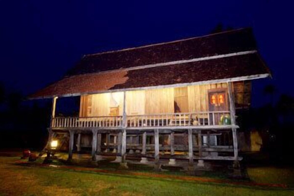 A two-story house with a balcony, a porch, and a visible door.