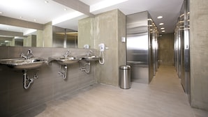 A modern bathroom with multiple sinks, a trash bin, and a mirror. - York Design Hotel (Taipei)
