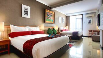 A spacious hotel room with a large bed, a desk, and a chair.
