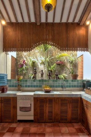 Una cocina con gabinetes de madera, salpicadero de azulejos y horno empotrado.