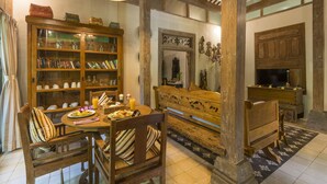 Ein gemütlicher Essbereich mit Holzkunst, einem Bücherregal und einem Esstisch, gedeckt mit Tellern und einer Kerze.