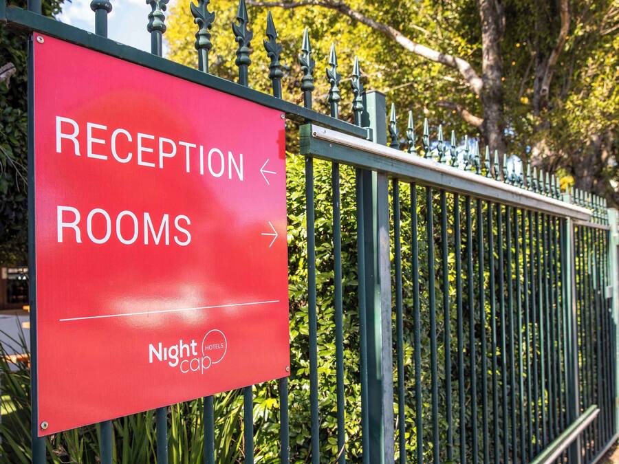 Un panneau rouge avec une inscription blanche indiquant « SALLES D’ACCUEIL », accompagné de flèches indiquant la direction.