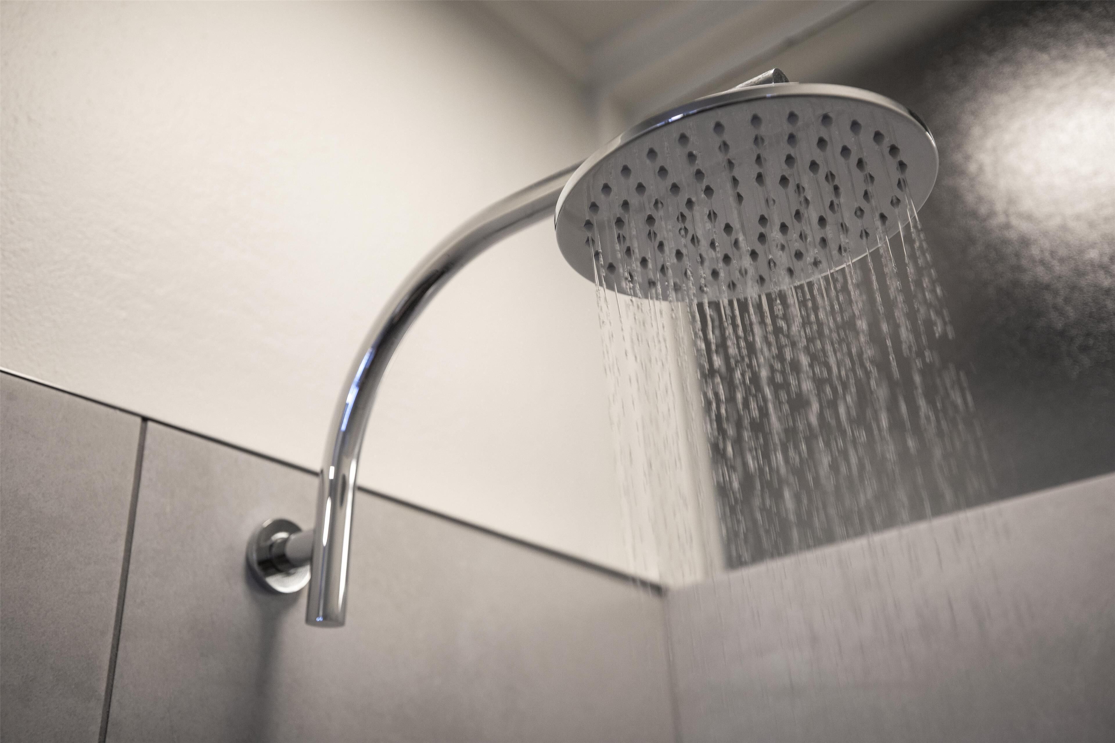 A modern showerhead with water flowing from it.