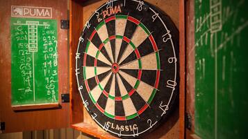 A dartboard with the brand name "PUMA" and a green chalkboard with cricket score markings.