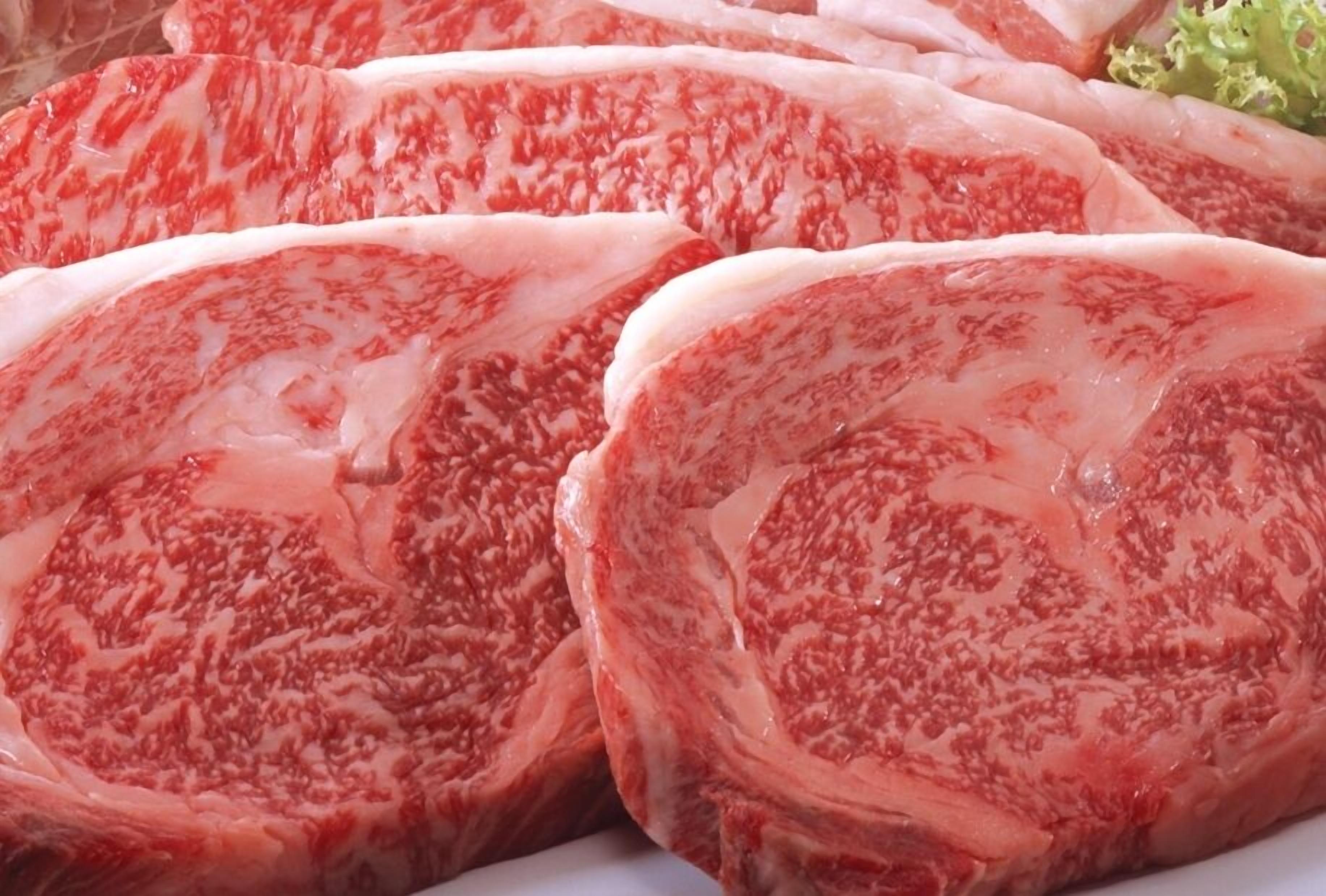 Primer plano de cortes de carne de res crudos con grasa intramuscular.