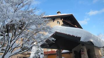 A building with a snow-covered roof and a stone chimney.